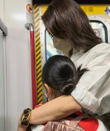 49岁黎姿带女儿乘坐地铁，背后有许许多一般路人