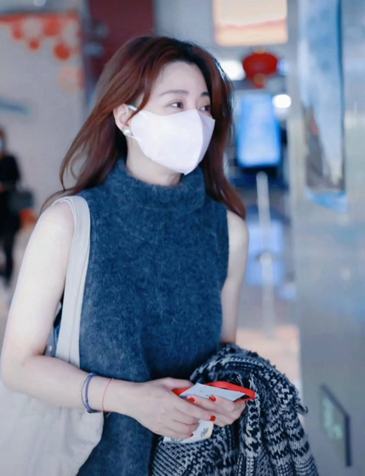 殷桃休假归来现身机场，她身穿高领毛衣背心，肤色白到发光