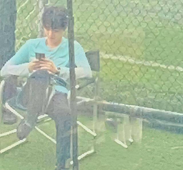 王俊凯《重生之门》拍摄片场，翘着二郎腿看手机，画面少年感十足