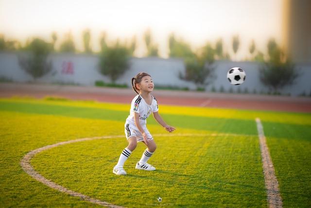 奶爸给7岁女儿拍踢足球写真,穿球服的小女孩太萌了