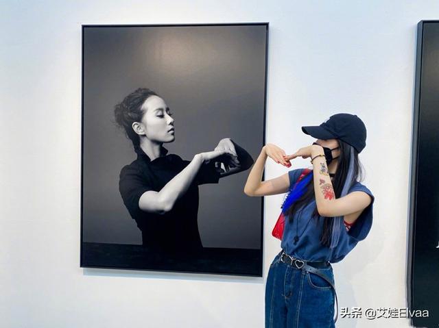 杨幂遛弯看展真悠闲，穿无袖反手大花臂抢镜，见自己海报俏皮合拍